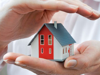 tiny house with a hand hovering over it